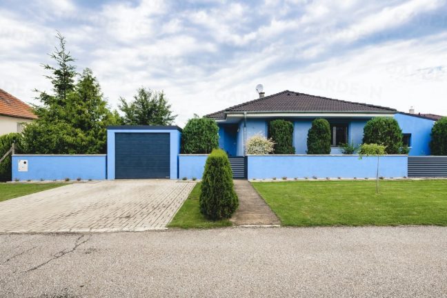 Eine blaue GARDEON Garage, angepasst an das Familienhaus