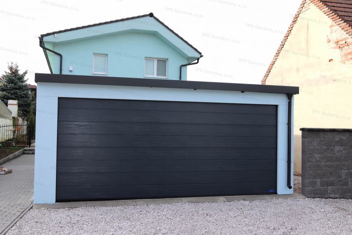 Eine montierte Garage mit Putz in der Farbe Menthol und einem Sektionaltor von Hörmann