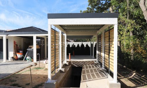 Ein montiertes Carport für 1 Auto in weiß mit Holzausfüllungen