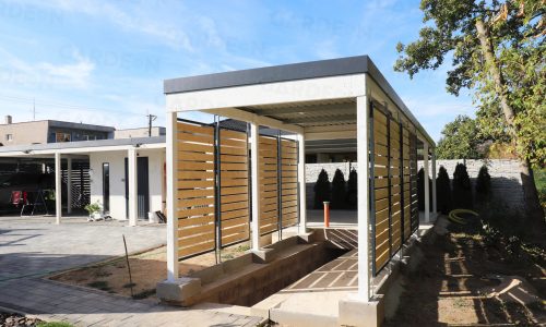 Ein montiertes Carport für 1 Auto in weiß mit Holzlatten