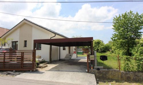 Ein braunes Doppelcarport von GARDEON bei einem Familienhaus mit Satteldach