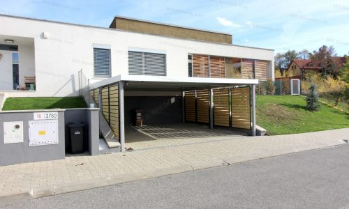 Ein weißes Carport mit Wandausfüllungen beim modernen Haus
