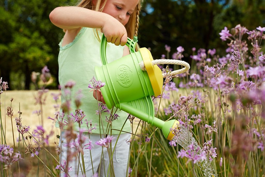 Ein Mädchen gießt den Garten