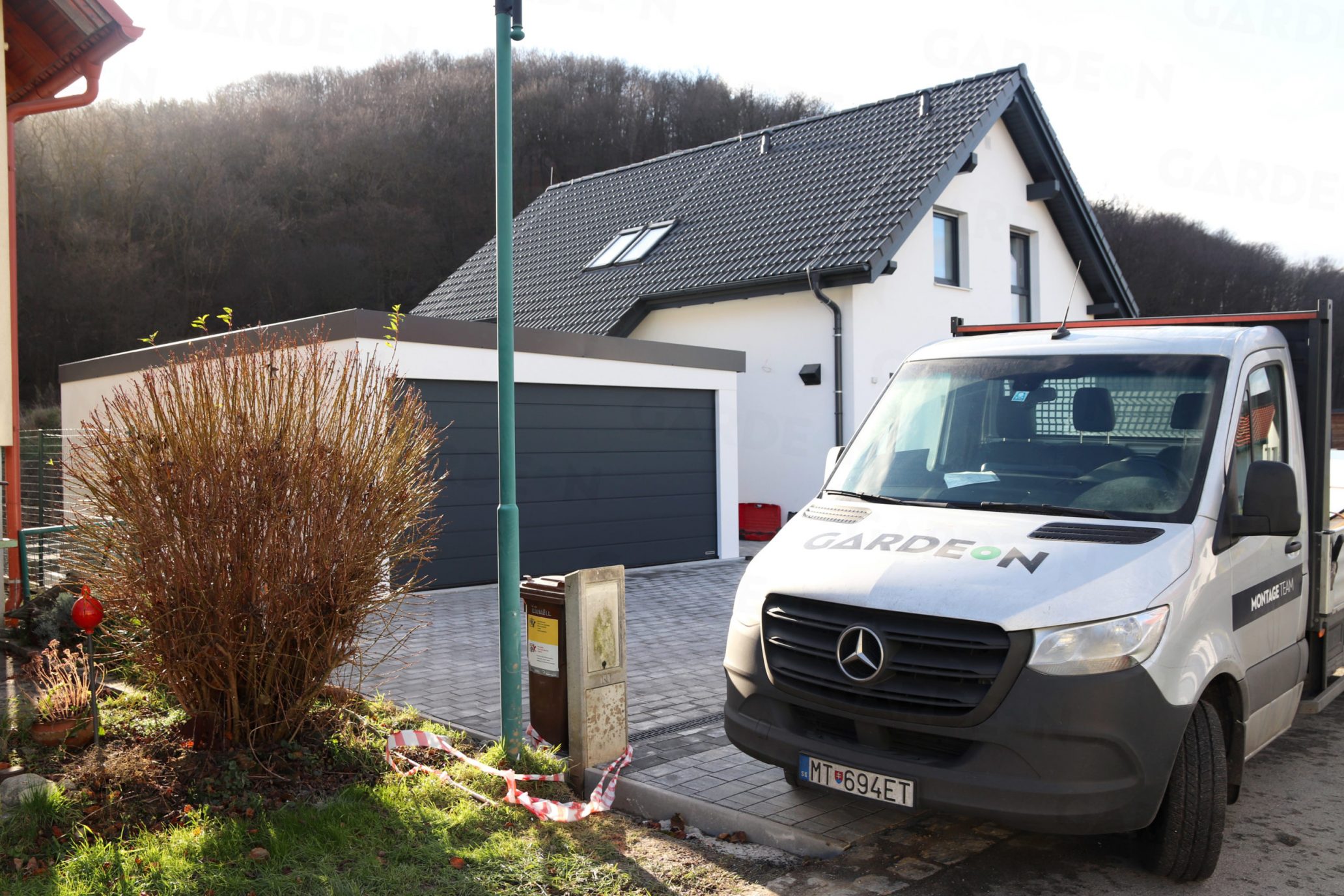 Eine montierte Doppelgarage von GARDEON bei einem Familienhaus mit Satteldach
