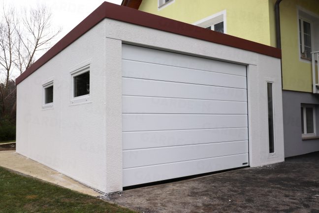 Eine weiße Garage mit einem weißen Tor von Hörmann