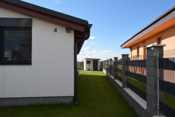 Das Gartenhäuschen von GARDEON mit Pultdach neben einem Haus mit Satteldach