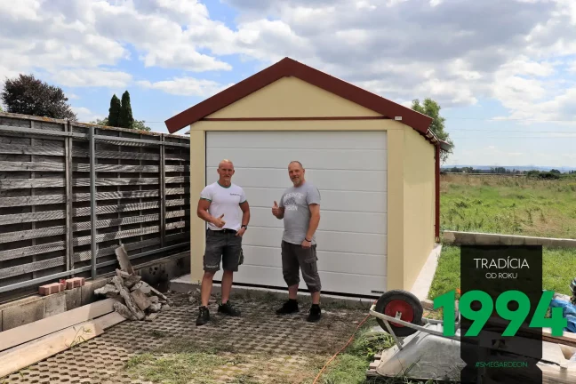 Zufriedener Kunde aus Österreich mit einem der GARDEON Monteure vor seiner neuen Garage mit Satteldach