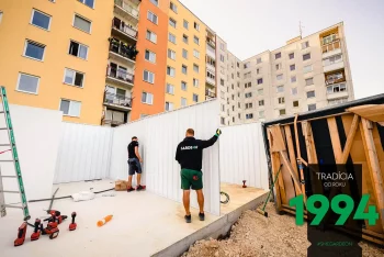 Die Monteure verschrauben ungedämmte Paneele einer Fertiggarage