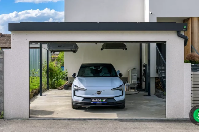 Parkplatz für ein Auto im Carport mit einem breiten Garagentor