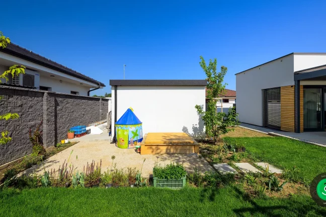 ein kleiner Spielplatz neben der weißen Garage