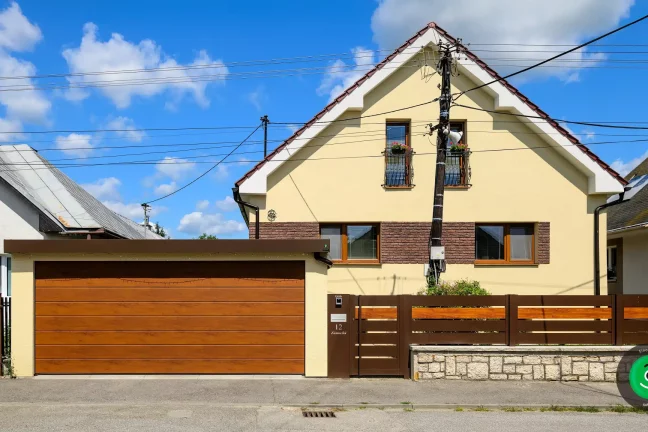 Ein Fertiggarage mit gelbem Putz und breitem braunem Garagentor.