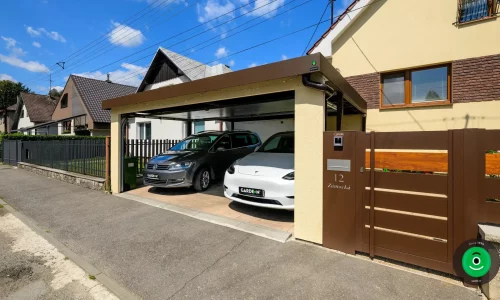 Kombination aus gelbem Putz und braunem Tor für einen modernen Carport.