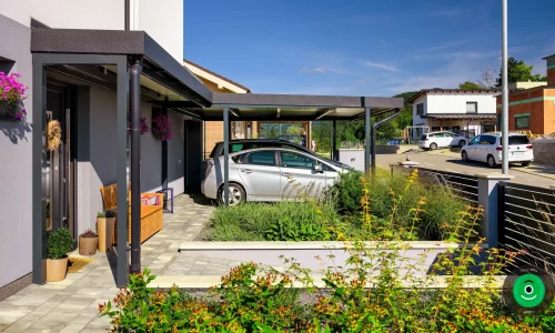 Ein Carport aus strapazierfähigem Material schützt zwei Autos vor Witterungseinflüssen.