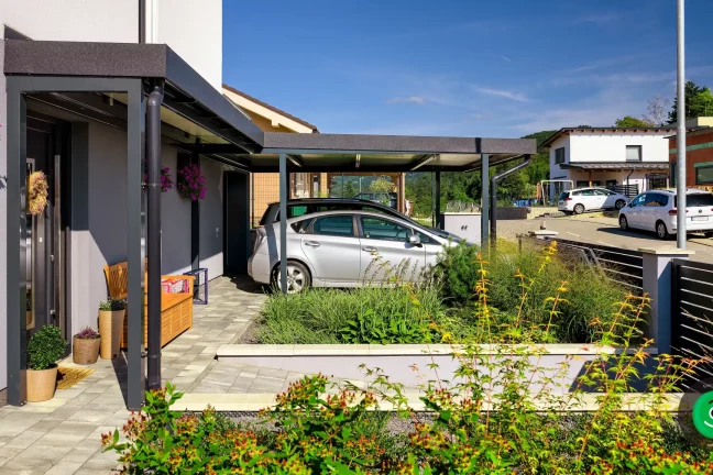 Ein Carport aus strapazierfähigem Material schützt zwei Autos vor Witterungseinflüssen.