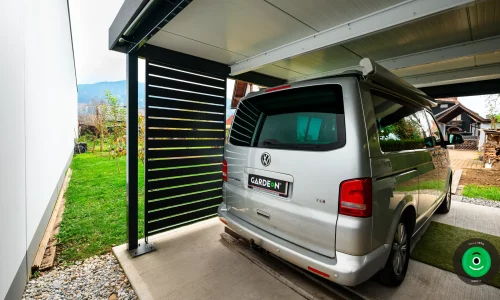 Auto unter einem Carport mit schwarzer Seitenwand aus Metall
