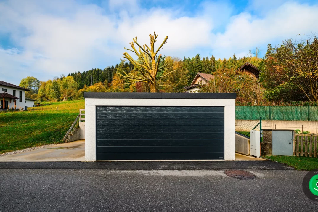 Eine große Garage mit einem schwarzen breiten Tor
