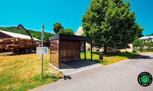 Moderner Unterstand in Form einer Bushaltestelle mit seitlicher Verkleidung.