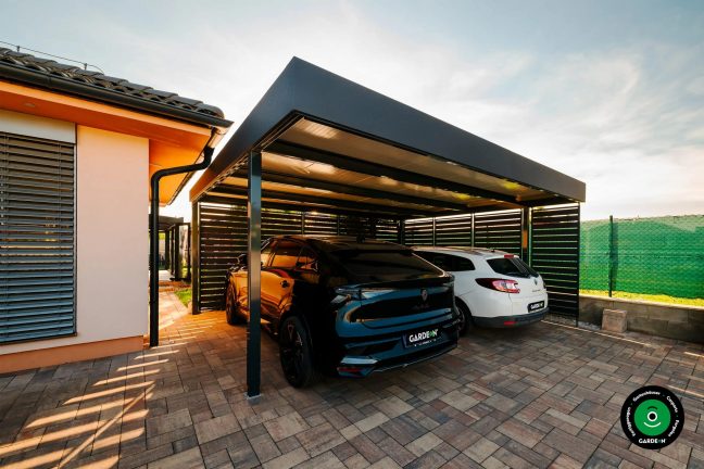 Überdachter Unterstand am Haus mit zwei geparkten Autos