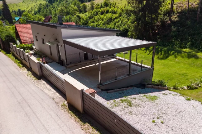 Luftansicht eines Carports mit Trapezblech-Dach am weißen Einfamilienhaus.