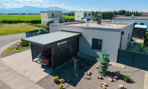 Anthrazitfarbenes Vordach mit Metallfüllung und Trapezblech am Einfamilienhaus.