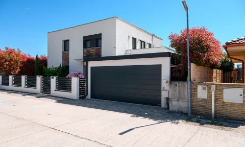 Moderner Carport mit Garagentor bei minimalistischem Einfamilienhaus