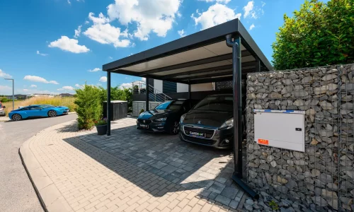 Doppelcarport in Anthrazit für zwei Autos an gepflasterter Zufahrt.