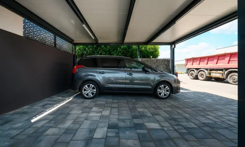 Innenansicht eines anthrazitfarbenen Carports mit gedämmtem Dach und geparktem Fahrzeug.