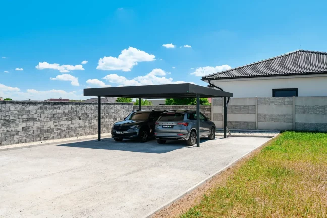 Doppelcarport in de Anthrazitfarbe mit Flachdach am Einfamilienhaus.
