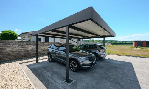 Flaches anthrazitfarbenes Carportdach schützt zwei SUV am Einfamilienhaus.