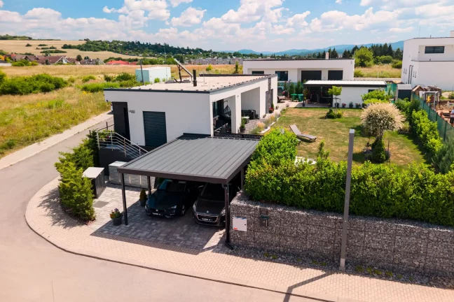 Luftansicht eines Doppel-Flachdach-Carports in Anthrazit an modernem Bungalow.