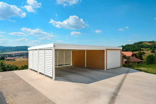 Garage mit angeschlossenem Carport, weißer Metallverkleidung und Ziegelputz.
