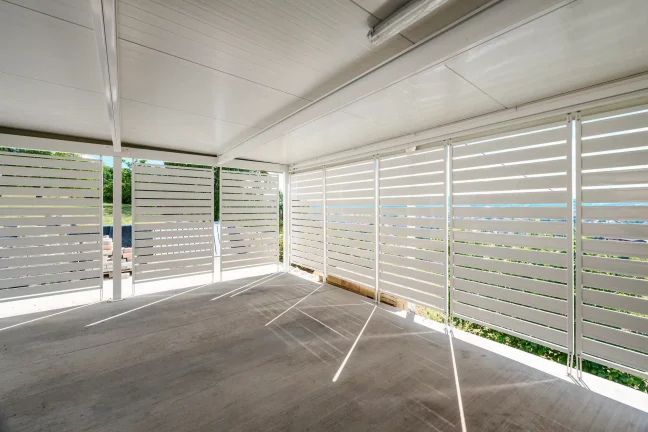 Innenansicht des weißen Carports mit horizontaler Metallverkleidung und isolierter Decke.