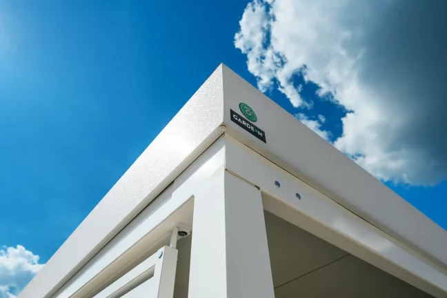 Ansicht von unten auf die weiße Attika des Carports mit Markenlogo.