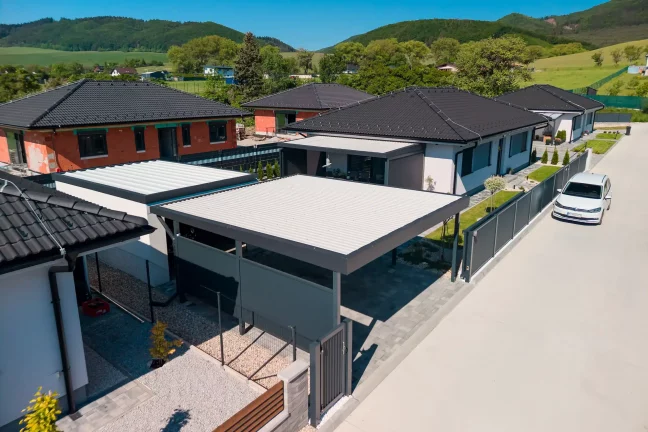 Garage mit Carport und Pultdach, Luftaufnahme einer anthrazitfarbenen Konstruktion neben einem Einfamilienhaus
