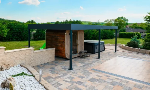 Anthrazitfarbene Pergola am Pool mit transparenter Abdeckung, weißer Kies und gepflasterte Fläche rundherum