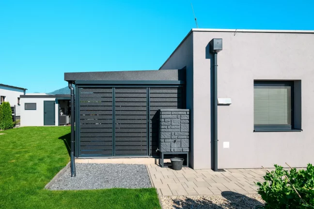 Waagerechte Metallfüllung eines anthrazitfarbenen Carports am Einfamilienhaus.
