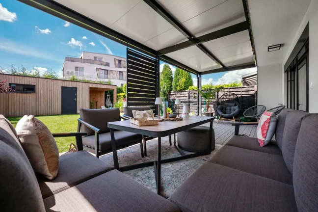 Innenansicht einer Pergola mit luxuriösen Gartenmöbeln, Blick in den Garten
