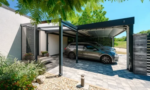 Auto unter dem Carport neben einer Steinsäule und einem Baumast