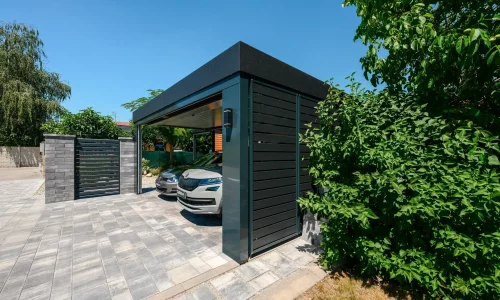 Blick auf den Carport mit zwei Autos von der gegenüberliegenden Seite