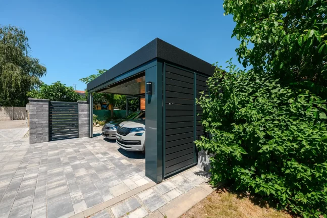 Blick auf den Carport mit zwei Autos von der gegenüberliegenden Seite