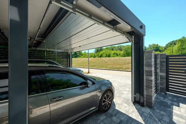 Blick vom Carport aus durch das geöffnete Tor auf die Straße