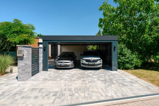 Vorderansicht des Carports mit geöffnetem Tor und zwei Autos