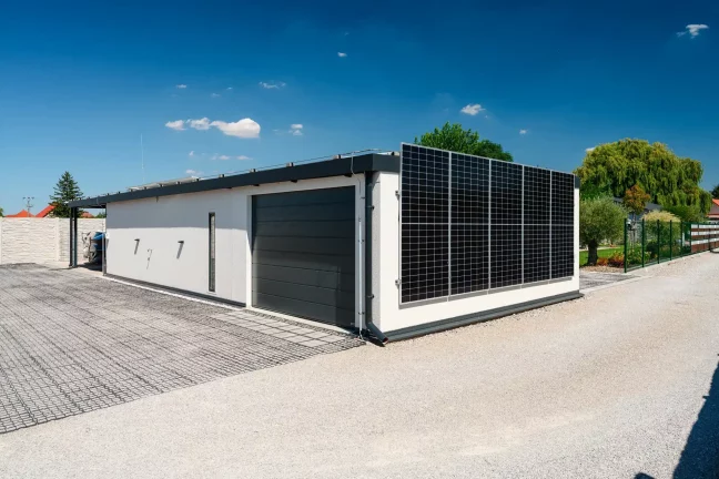 Seitenansicht des Hauses mit Garagentor und Solarmodulen