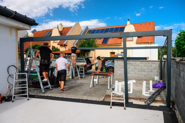 Monteure errichten die Stahlkonstruktion einer Überdachung an der Straße