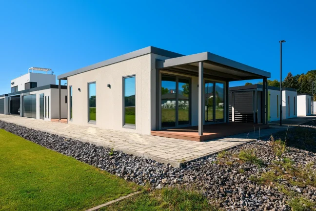 Seitenansicht des Tiny Houses mit überdachter Terrasse und Kiesstreifen