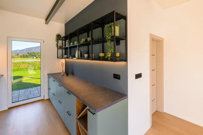 Küchenzeile mit Regalen und Eingangstür des Tiny Houses