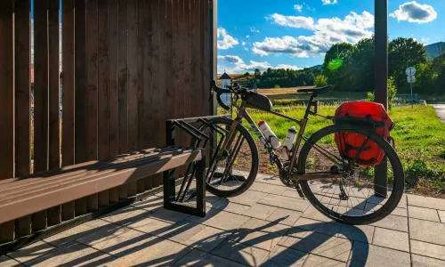 Fahrrad im Ständer neben der Sitzbank unter der Haltestellenüberdachung
